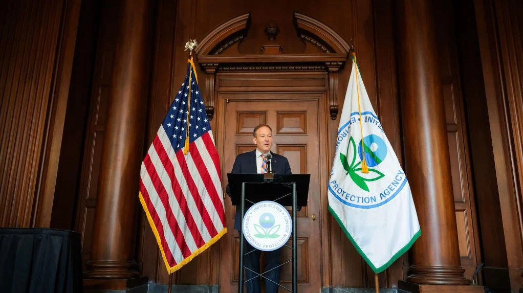EPA administrator Lee Zeldin stands at podium with flags behind him