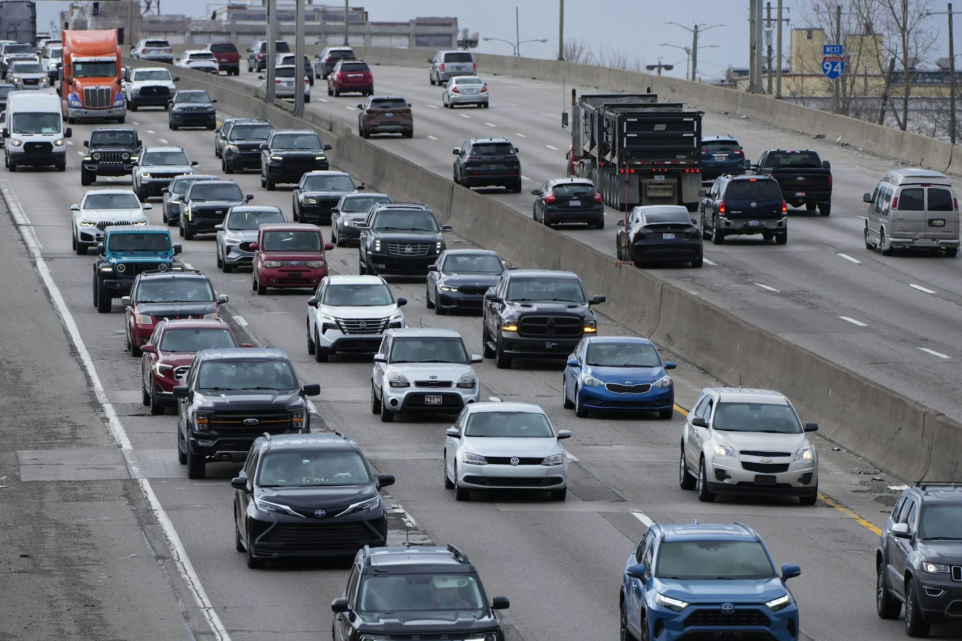 cars can be seen driving forward in several lanes on a major highway
