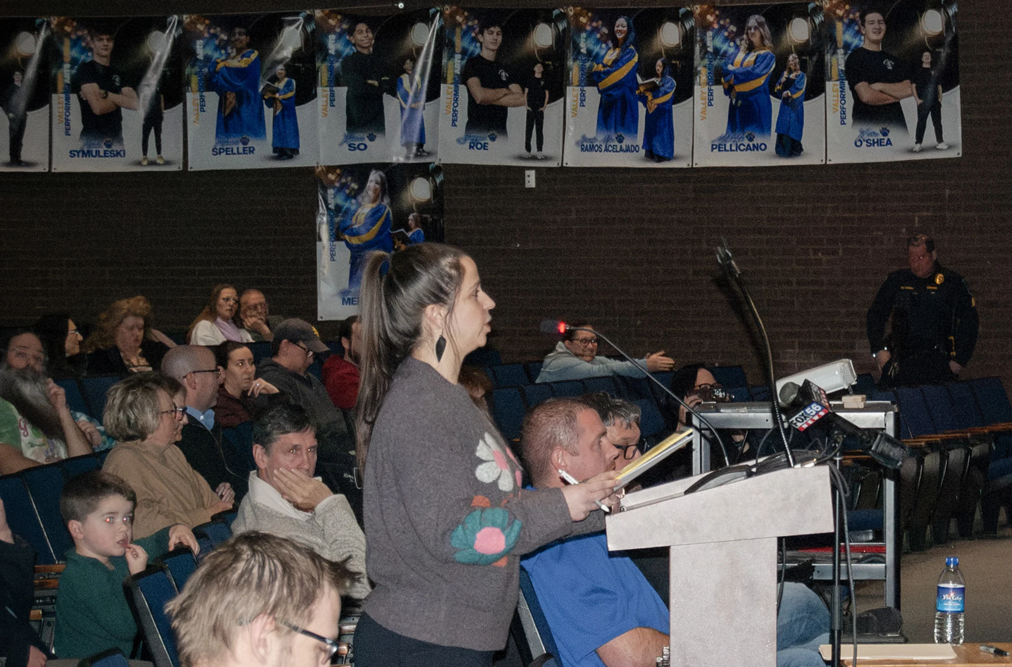 Tamara Misewicz-Healey speaks at a podium in an auditorium full of people.
