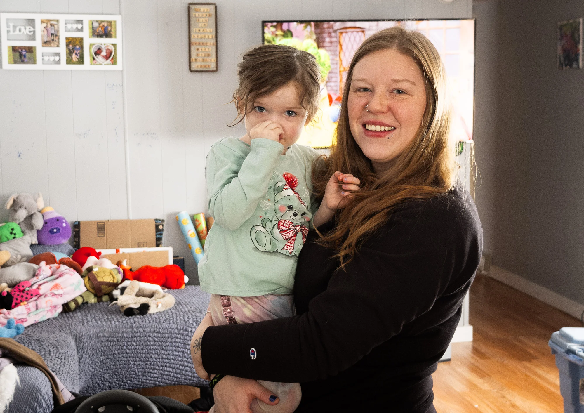 Candace May holds her young daughter, Nova, inside their home.