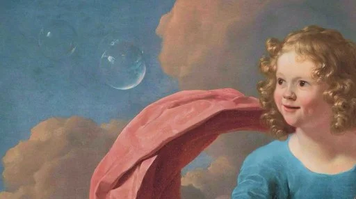 A young child with curly hair and a blue shirt stands in front of a cloudy sky with two floating soap bubbles and a pink fabric draped behind them.